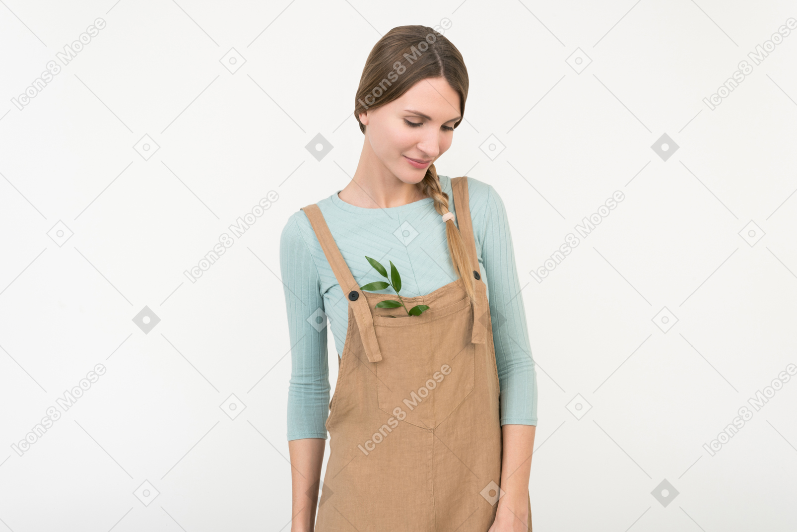 Young female farmer standing with green twig in her overalls