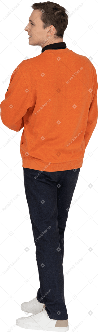 Young man in orange sweatshirt standing