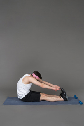 Young man performing toe touch bending