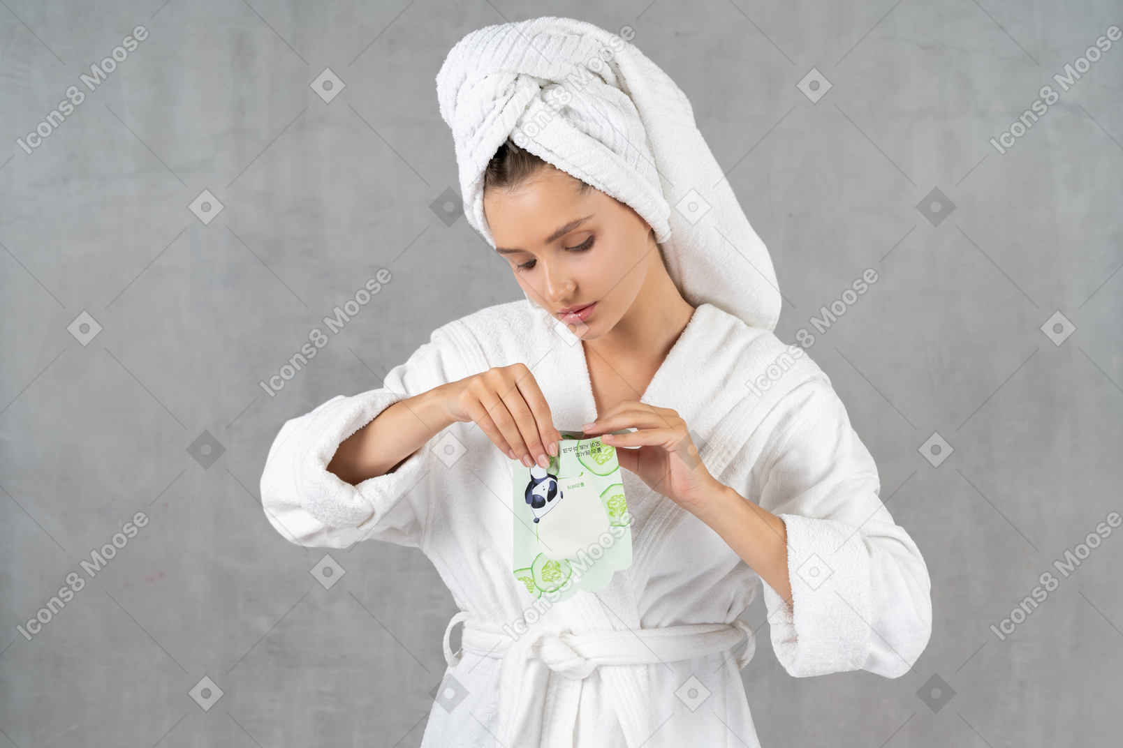 Woman in bathrobe opening a sheet mask pack