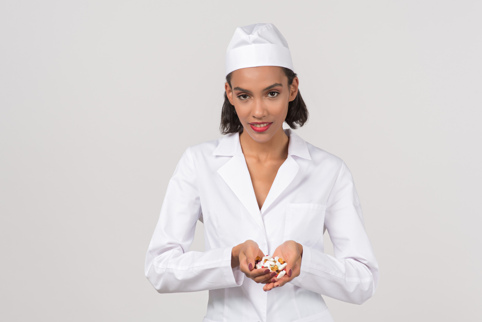 Attractive female doctor holding some pills