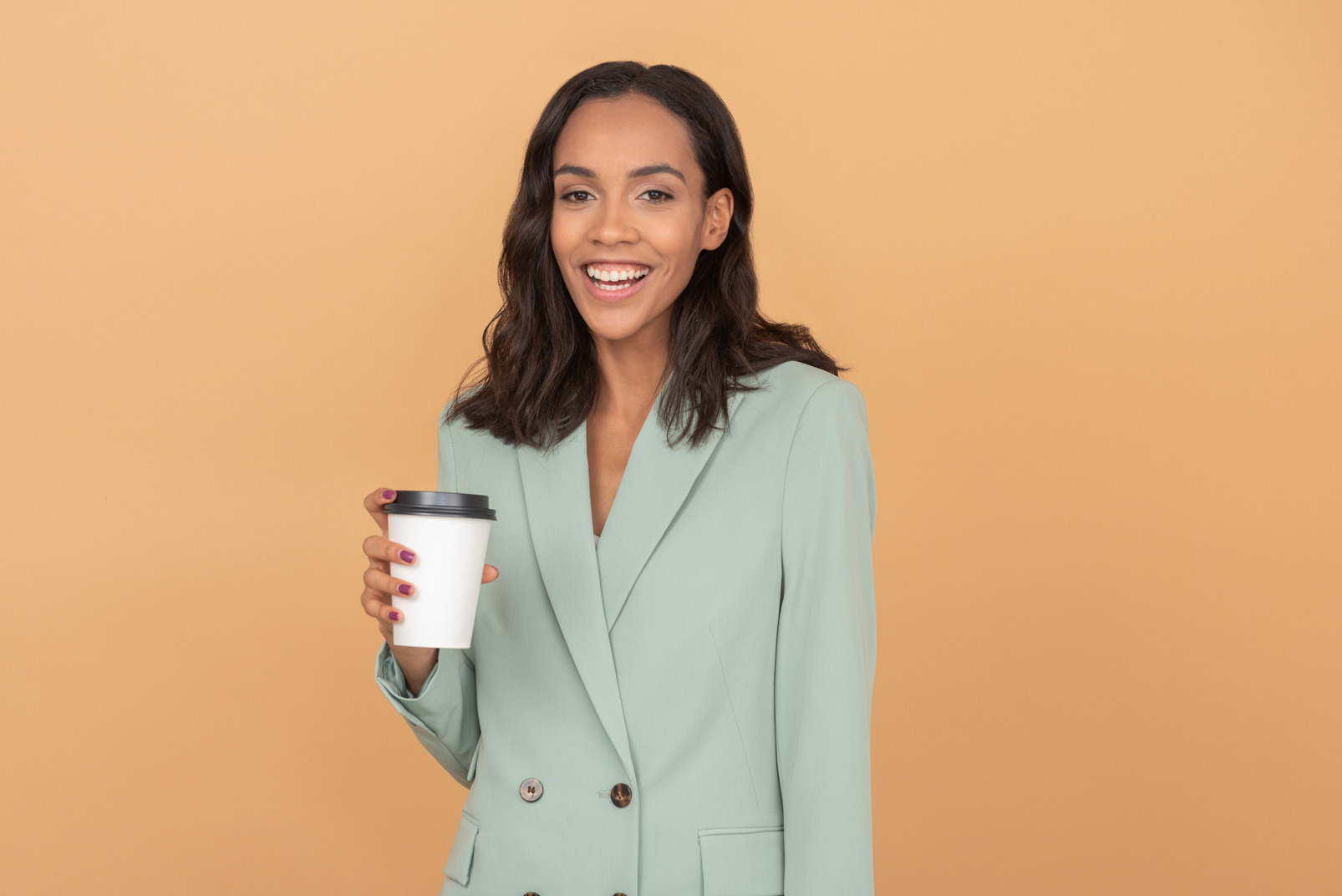 Smiling young business woman holding a cup of coffee