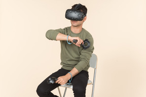 Young caucasian guy playing a virtual reality game