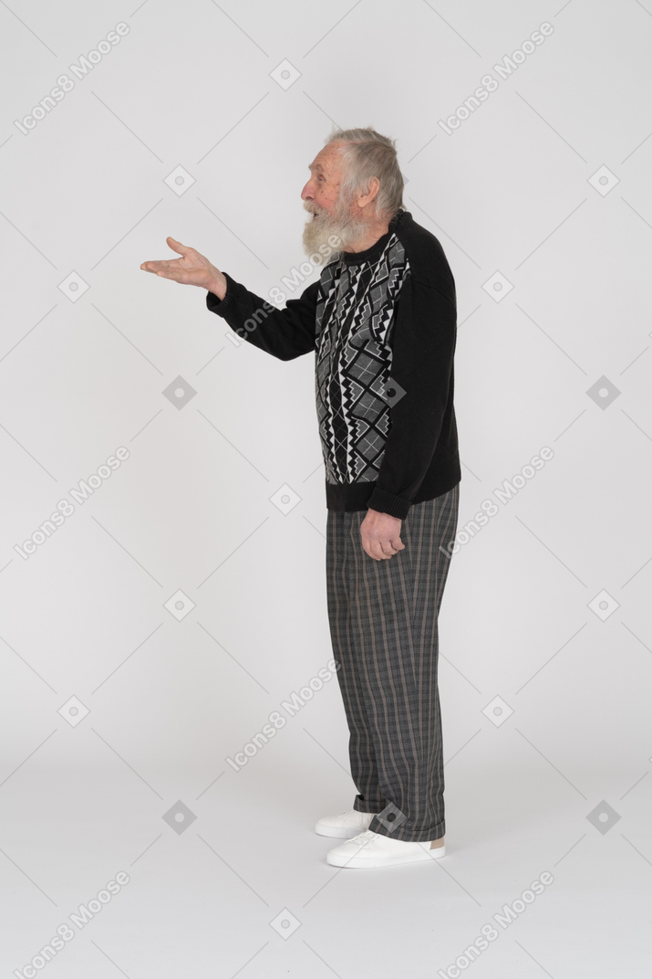 Side view of an old man holding up his hand and laughing