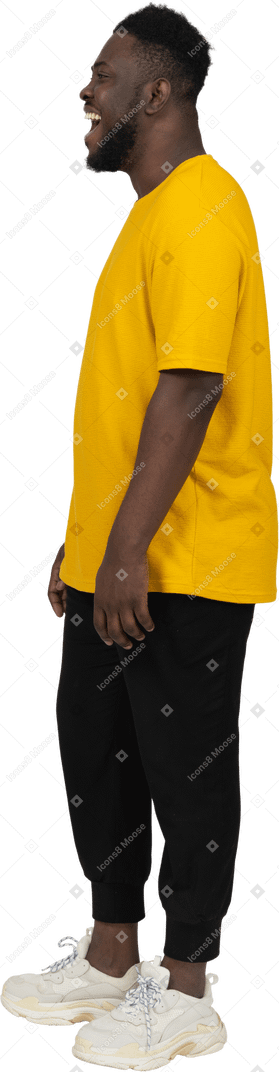 노란색 티셔츠를 입고 웃고 있는 검은 피부의 젊은 남자의 옆모습