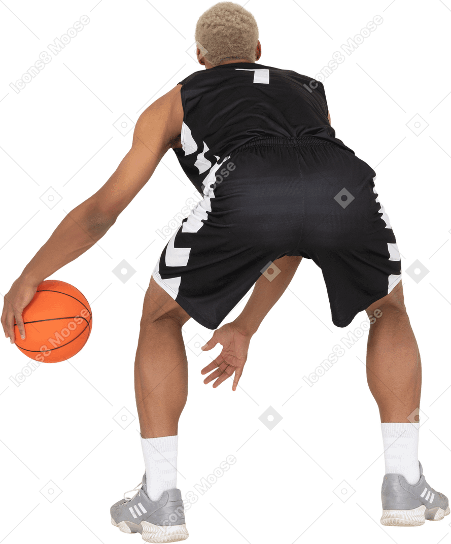 Back view of a young male basketball player doing dribbling