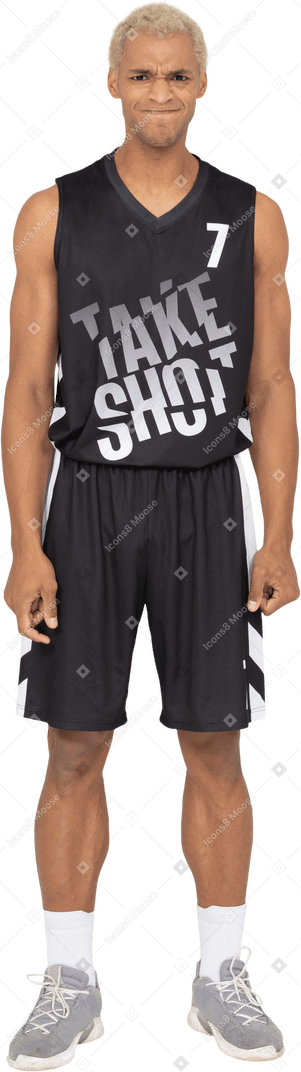 Vista frontale di un giovane giocatore di basket maschile dispiaciuto che stringe i pugni