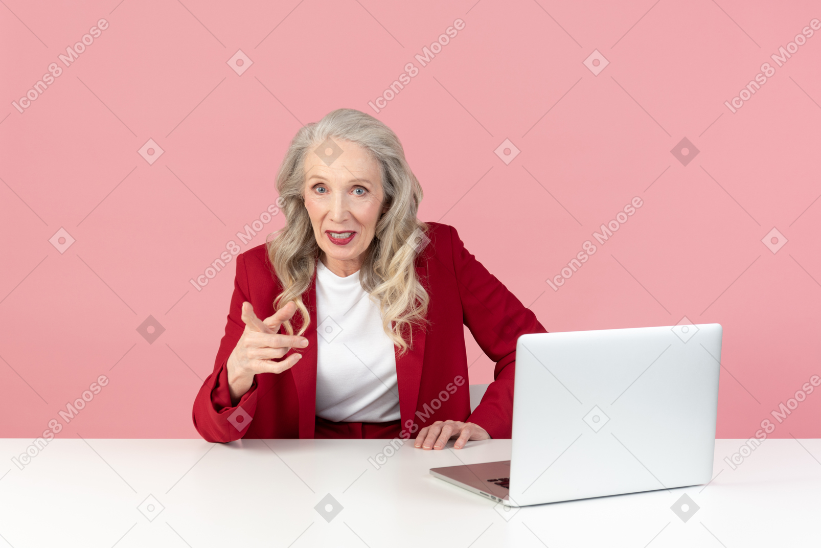 Mujer de edad sentada en la mesa y parece hablar con alguien.