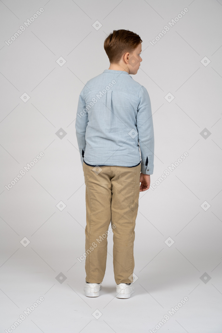 Vista posteriore di un ragazzo in abiti casual che guarda da parte