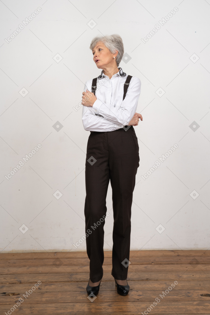 Vista frontal de uma senhora com roupa de escritório cruzando as mãos