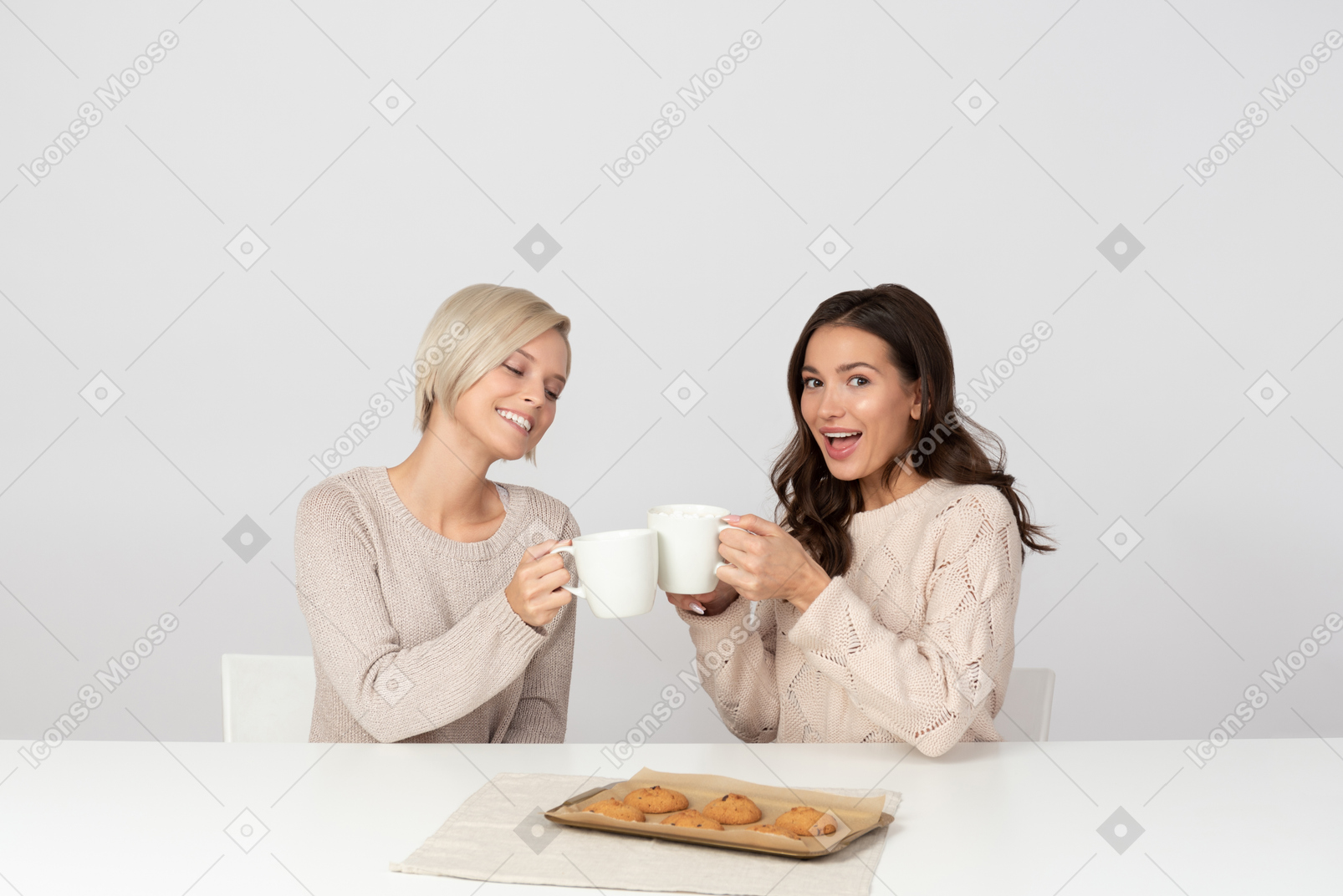 Young women eating homemade cookies and drinking coffee