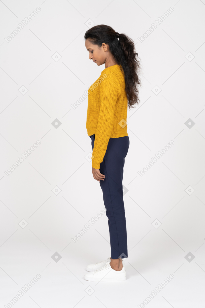 Side view of a beautiful girl in casual clothes looking down