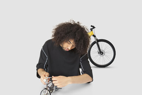 A man assembling a miniature bicycle