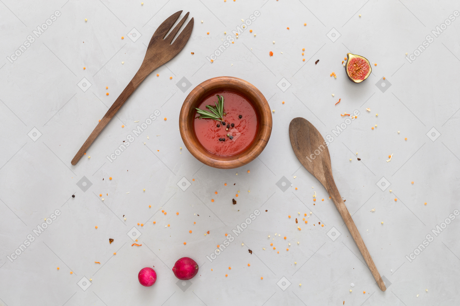 A bowl of tomato sauce, wooden fork and spoon, some radish and a fig