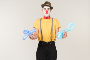 Male clown holding balloon figures
