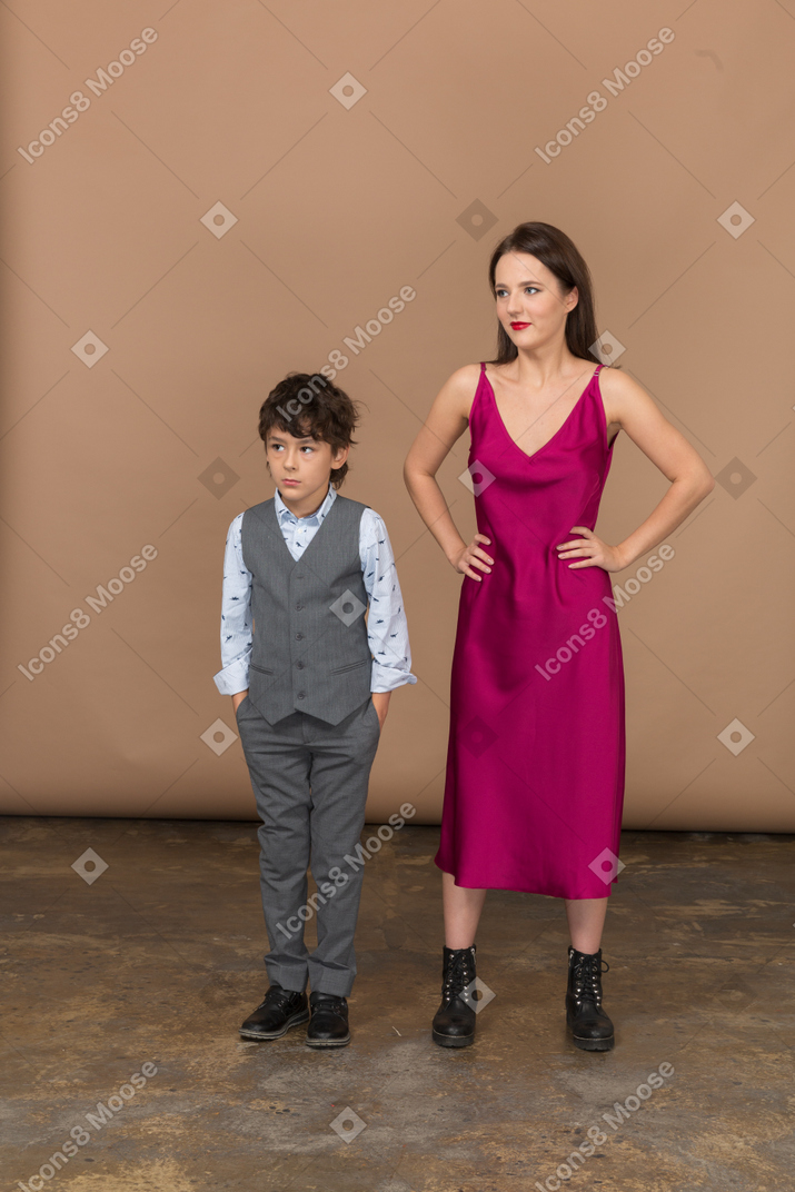 Mujer joven de pie con un niño y sonriendo