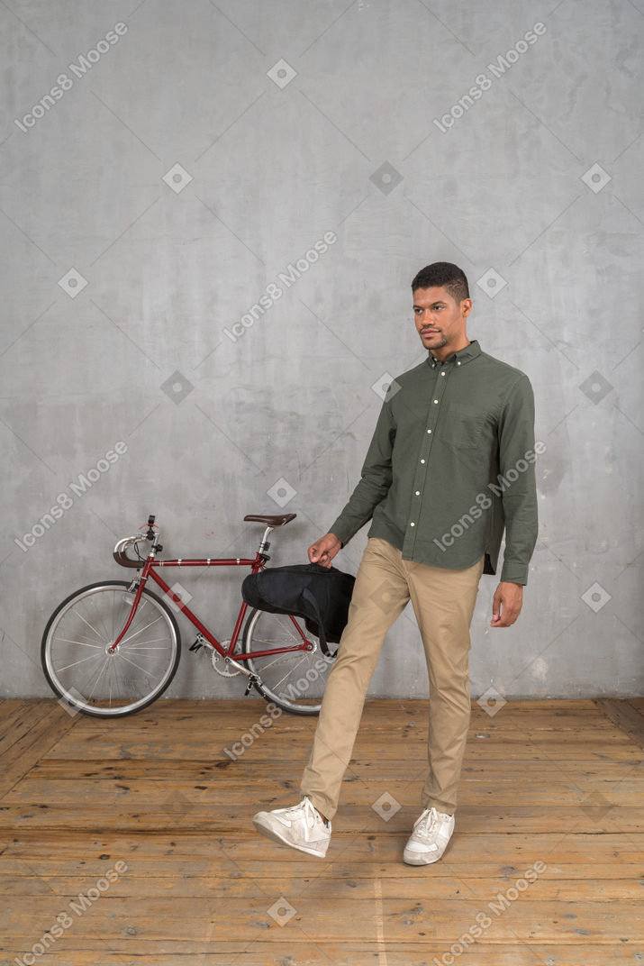Man in casual clothes walking with a ukulele case
