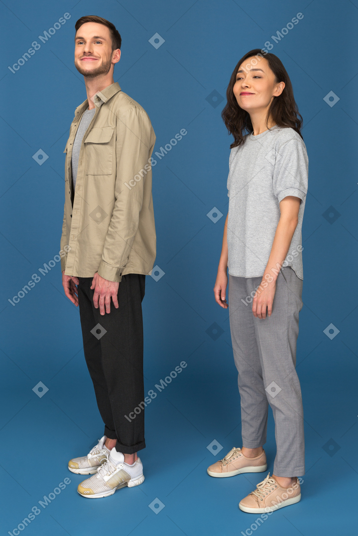 Cheerful man and woman standing half turned to camera