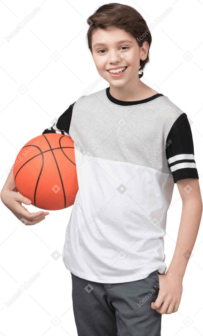 Мальчик держит баскетбольный мяч и улыбается