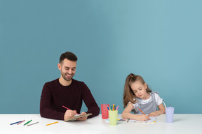 Papa et sa fille font de leur mieux pour dessiner