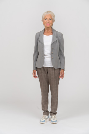 Front view of a happy old woman in suit looking at camera