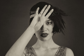 Close-up of a flapper covering face with one palm