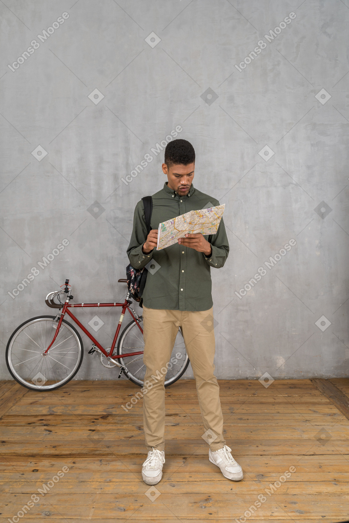 Vista frontal de um homem examinando um mapa cuidadosamente