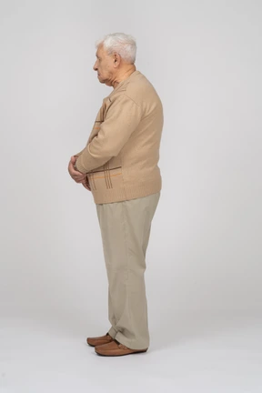 Side view of an old man in casual clothes standing still
