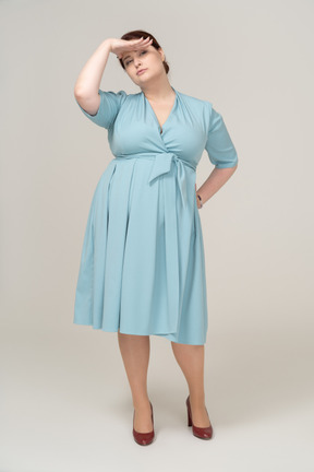 Front view of a woman in blue dress looking for someone