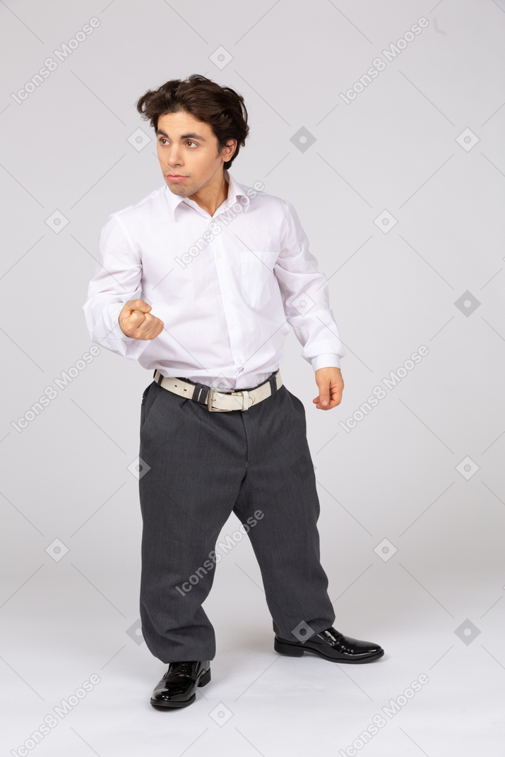 Businessman looking aside and threatening with fist