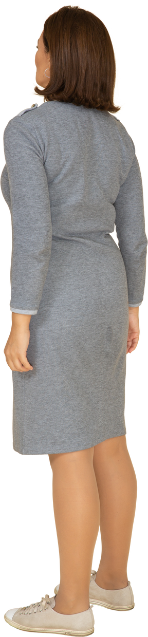 Vista posteriore di una donna in abito grigio in posa
