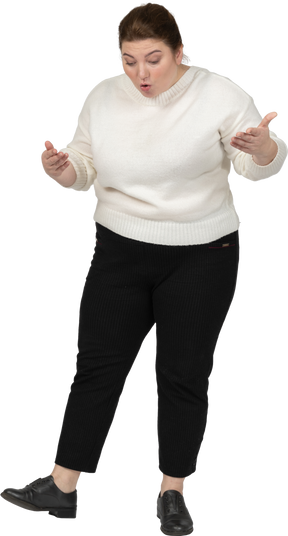 Vista frontal de uma mulher plus size com suéter branco olhando para baixo