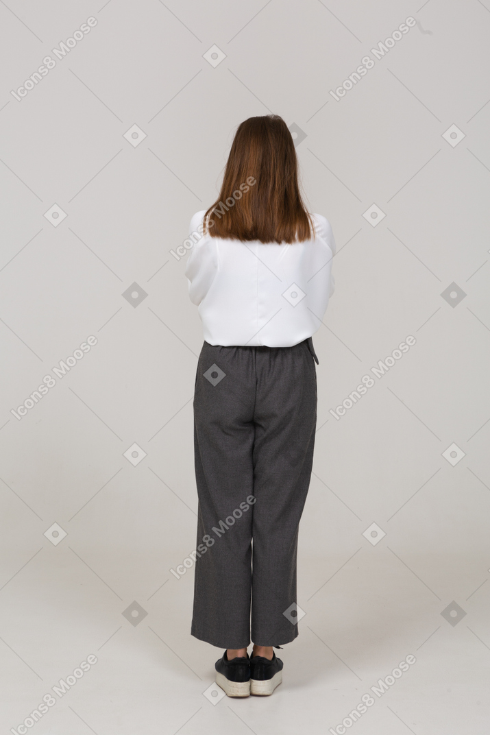 Back view of a praying young lady in office clothing holding hands together