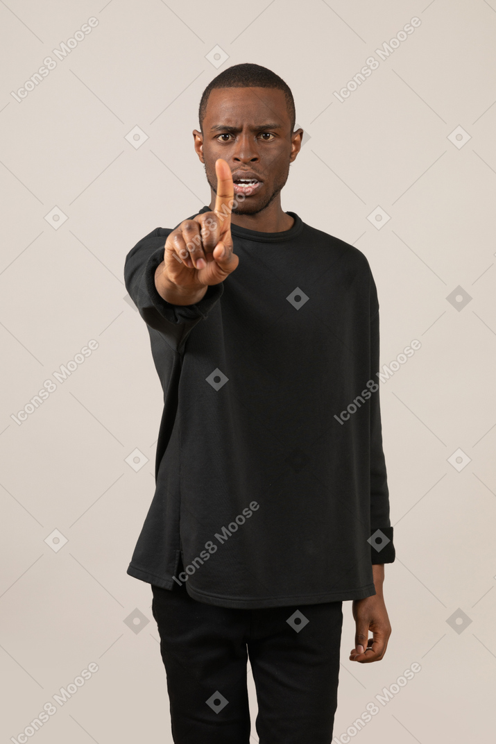 Young man making warning with gesture