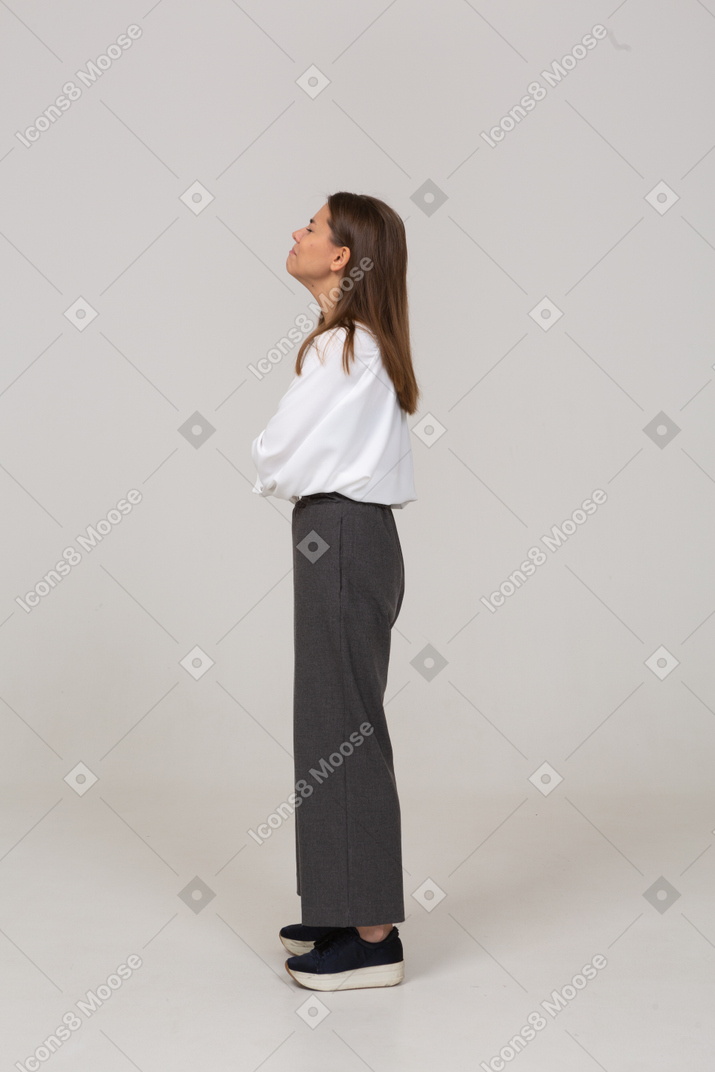 Vista lateral de una señorita llorando en ropa de oficina cruzando los brazos