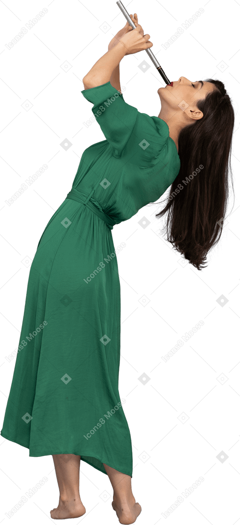 Side view of a young lady in green dress playing flute while leaning back