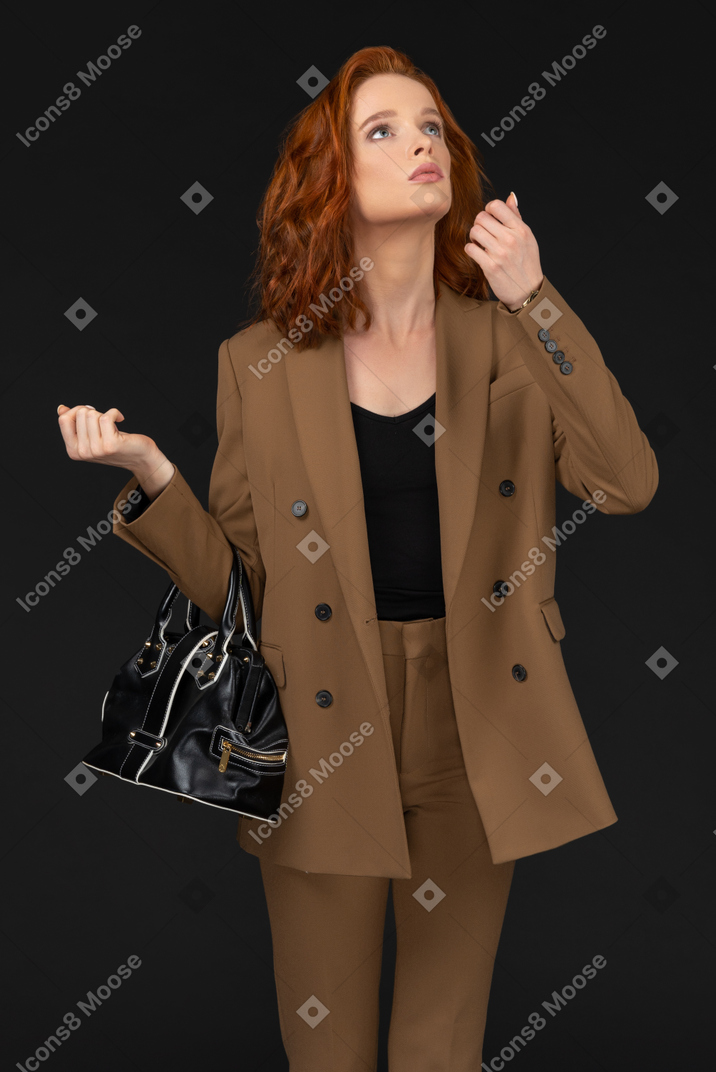 Молодая женщина в коричневом костюме отвлекается