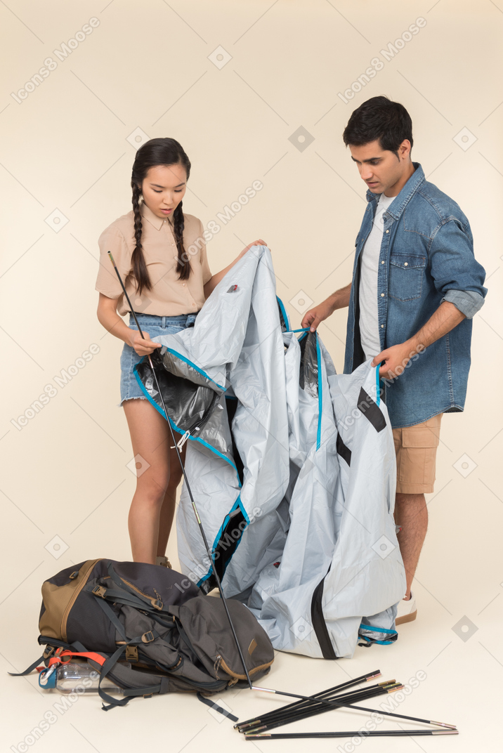 Jeune couple interracial installant une tente