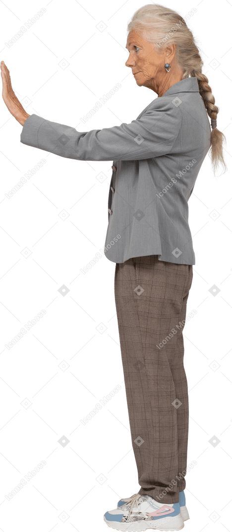 Vista laterale di una vecchia signora in abito che mostra il gesto di arresto