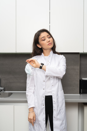 Female scientist taking off medical mask