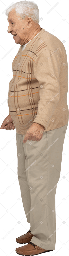 Seitenansicht eines glücklichen alten mannes in freizeitkleidung, der mit geballten fäusten steht