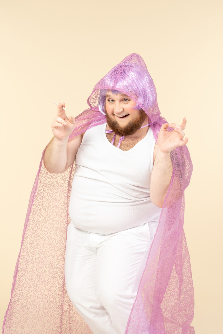 Young plump man dressed as a fairy doing scary expression