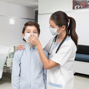 A nurse adjusts a boy's mask