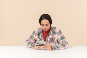 An asian geek guy in a checkered shirt