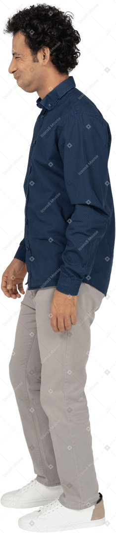 Vue latérale d'un homme en vêtements décontractés faisant des grimaces