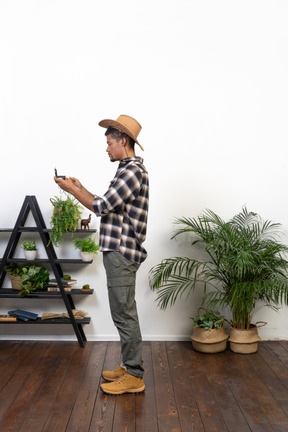 Side view of a tourist in a cowboy hat examining the compass