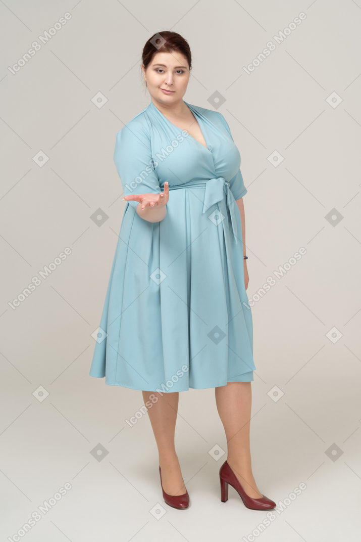 一个穿着蓝色裙子的女人的前视图打手势