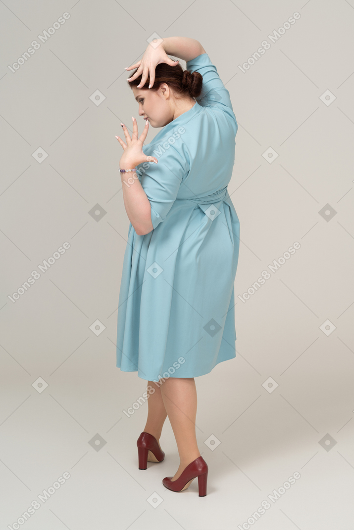 프로필에서 포즈를 취하는 파란 드레스를 입은 여자
