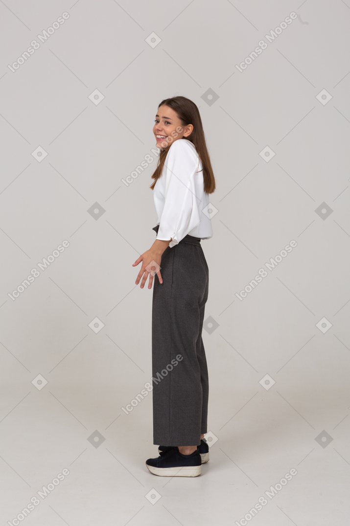 Vista de tres cuartos de una joven sonriente en ropa de oficina extendiendo los dedos