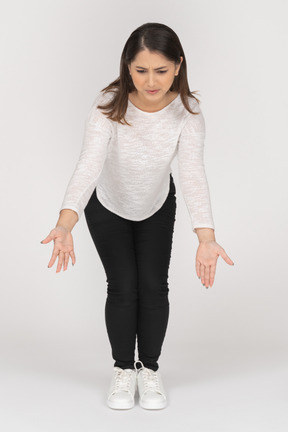 Front view of a young indian female in casual clothes leaning forward and outspreading arms